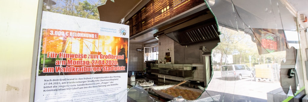 Die Scheibe eines Dönerimbisses in Waldkraiburg wurde eingeworfen. An dem Fenster klebte noch ein Fahndungsaufruf, nachdem ein Supermarkt in Flammen aufgegangen war.