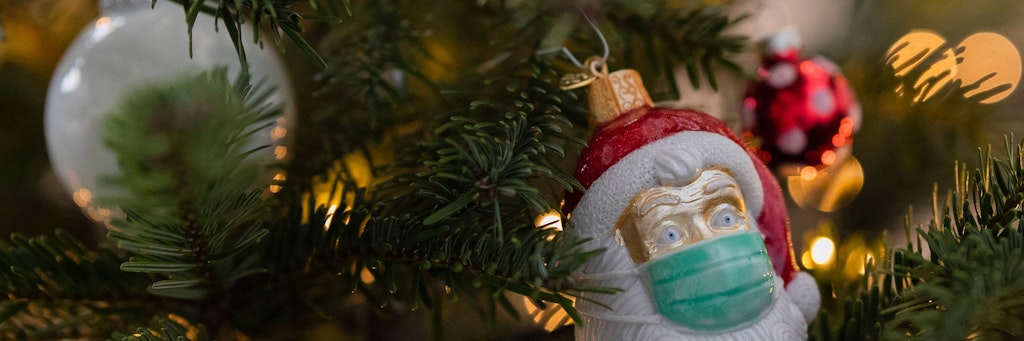 Weihnachtsschmuck in Form eines Weihnachtsmannes, der eine Maske trägt (Symbolbild).