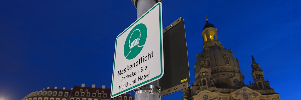 In Dresden weist ein Schild auf die Maskenpflicht hin. Sachsen ist absoluter Corona-Hotspot.