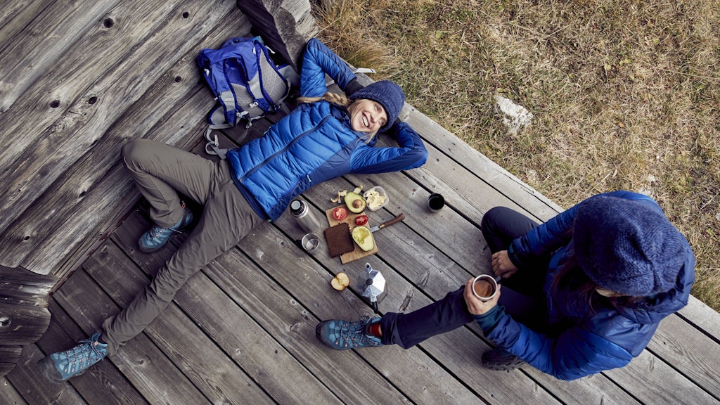 Ein Paar beim Picknick während eines Winterspaziergangs. Foto: imago images/Westend61/Philipp Nemenz
