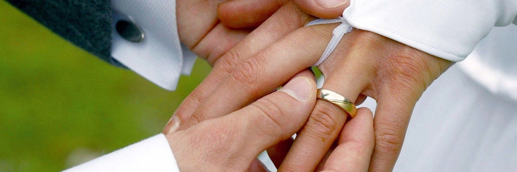 Der Bräutigam streift bei der Trauung seiner Braut den Ehering über den Finger (Symbolfoto).