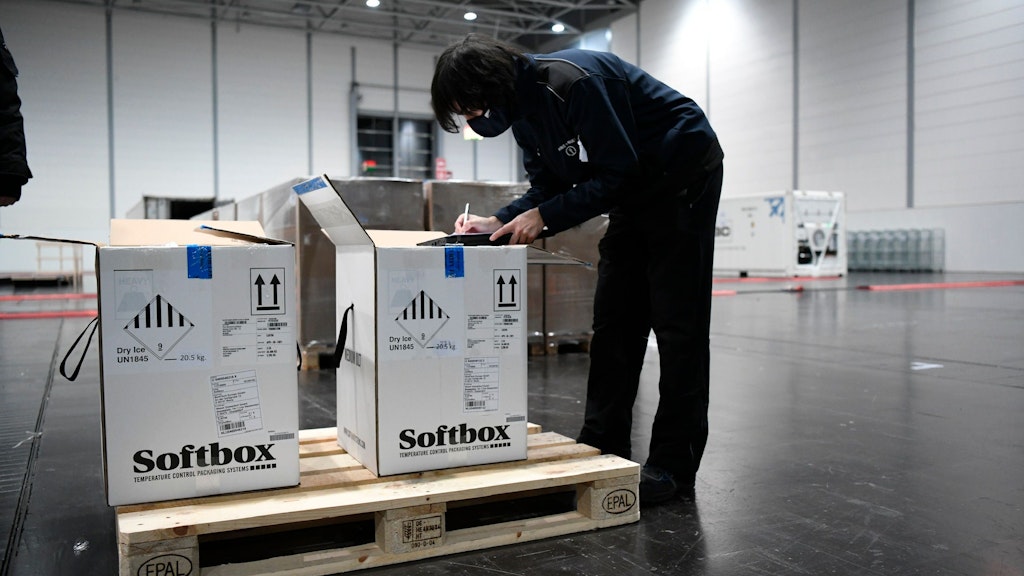  Mitarbeiter verschiedener Logistikunternehmen nehmen den Corona-Impfstoff im Zentrallager von Nordrhein-Westfalen an.