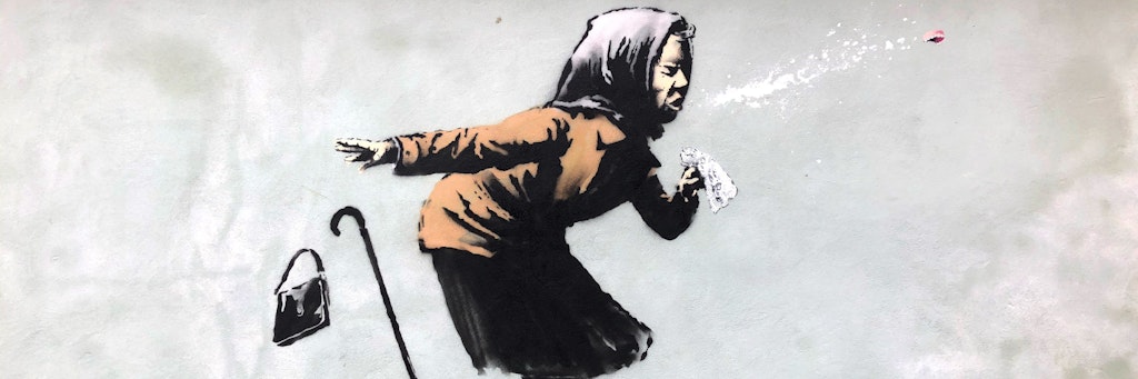 Eine ältere Frau, die so stark niest, dass ihr das Gebiss wegfliegt. Das Graffiti ist an einer Hauswand in der britischen Stadt Bristol.