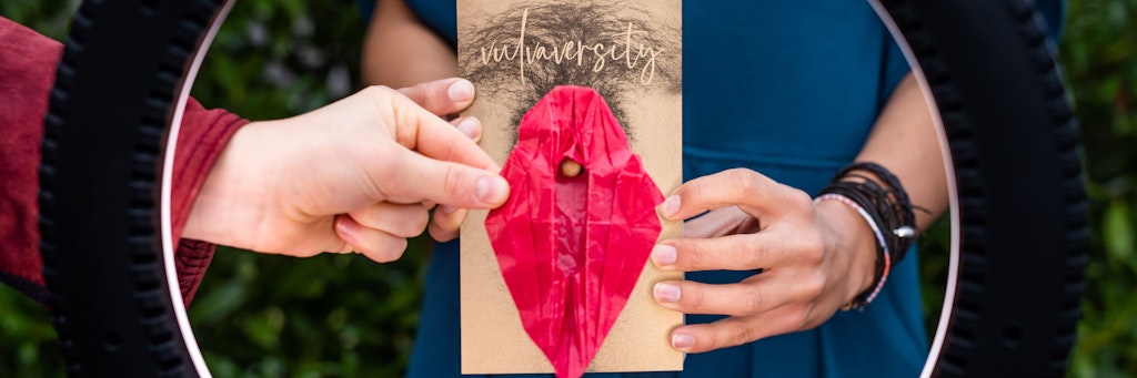 Ein Mitglied des Freiburger Kollektivs Vulvaversity hält ein Origami-Modell einer Vulva.