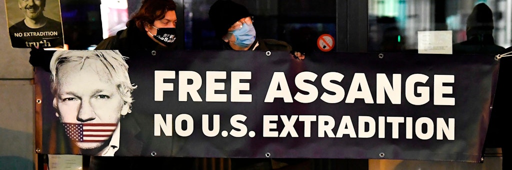 Protesters hold a sign to support WikiLeaks founder Julian Assange in front of the EU British Embassy in Brussels on December 07, 2020. (Photo by JOHN THYS / AFP)