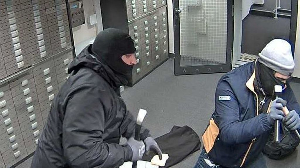 Zwei der maskierten Männer während des Einbruchs.