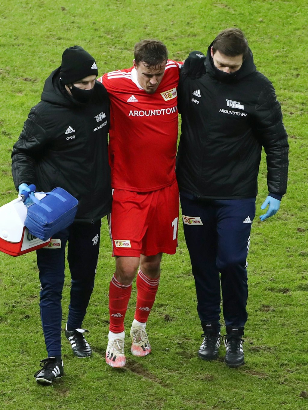 Gestützt von der medizinischen Abteilung der Eisernen humpelt Max Kruse vom Feld.
