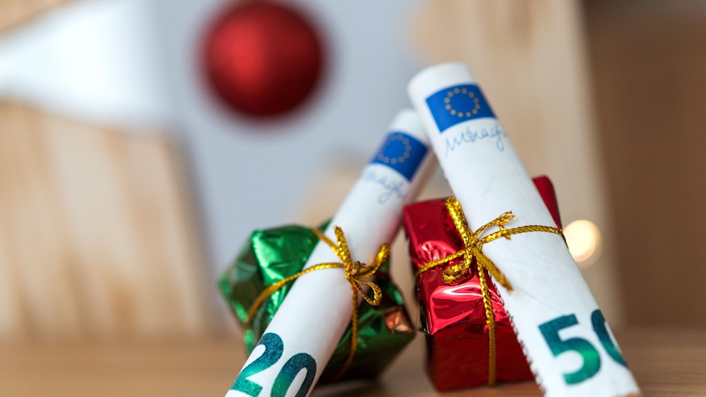 Als Geschenk verpackte 20- und 50-Euro-Banknoten liegen auf einem Tisch. Weihnachten steht vor der Tür und damit auch der Stress, die richtigen Geschenke zu finden. Noch beliebter als liebevoll ausgesuchte Überraschungen scheinen nur Geldgeschenke zu sein. 