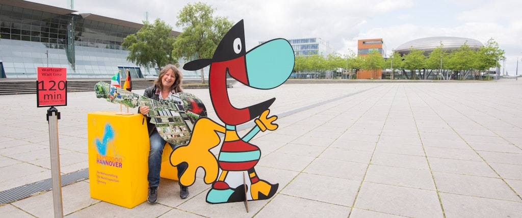 Gil Koebberling, Vorsitzende des Exposeeums sitzt mit Exponaten des Museums auf der Expo-Plaza. 