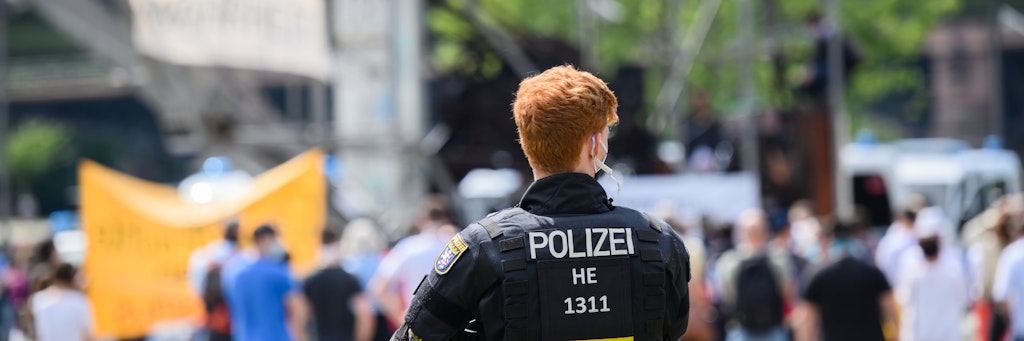 Ein Polizist beobachtet die Kundgebung in Frankfurt/Main. 