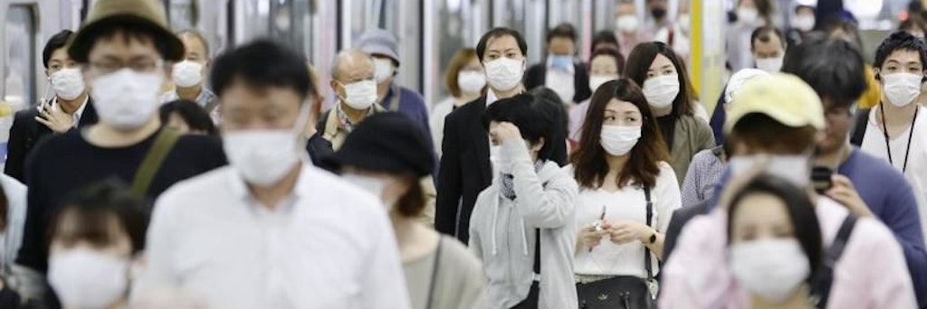 Pendler mit Gesichtsmasken am Bahnhof Fukuoka im Südwesten Japans.