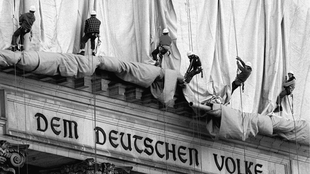 Die Stoffbahnen werden ausgerollt, verdecken gleich den Spruch über dem Portal: Dem deutschen Volke.