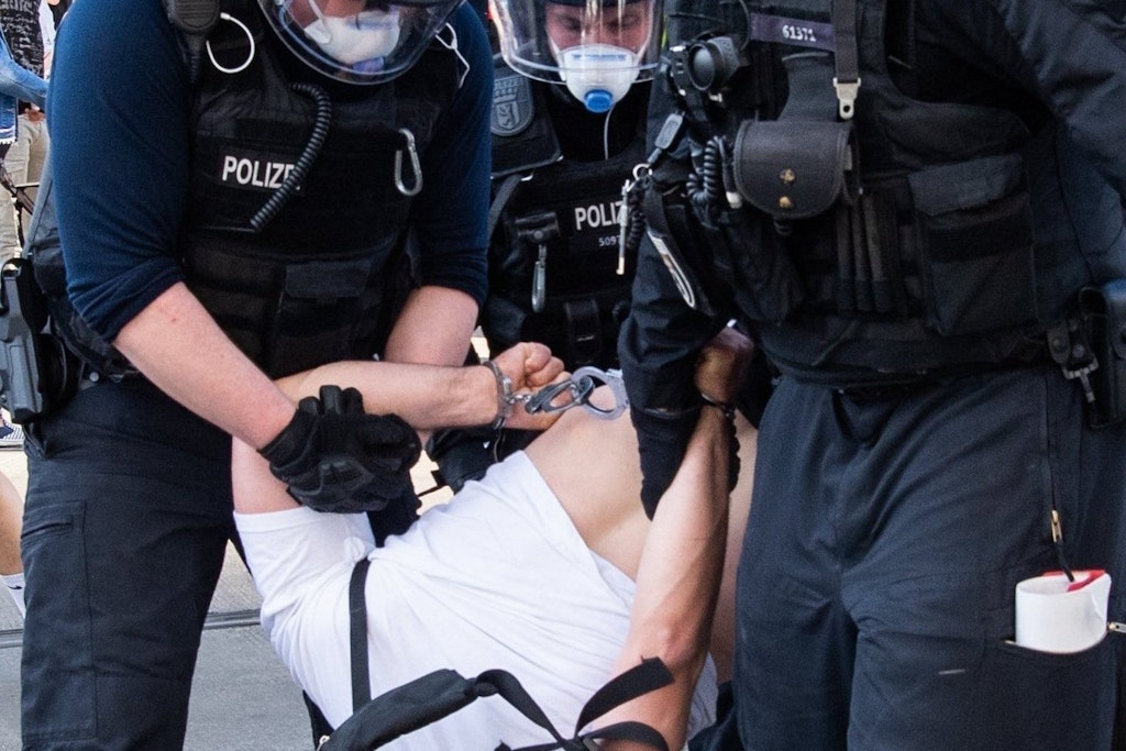 Polizisten führen bei einer Demonstration auf dem Alexanderplatz einen Mann ab.