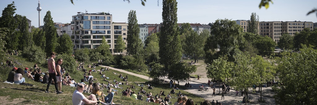 Menschen sitzen auf einer Wiese im Mauerpark in Berlin Prenzlauer Berg.