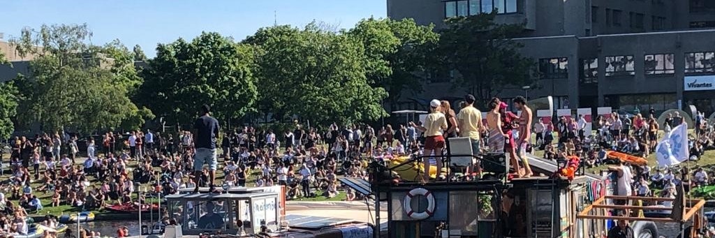 Feiernde Menschenmengen am Ufer des Landwehrkanals, im Hintergrund das Vivantes-Klinikum am Urban.