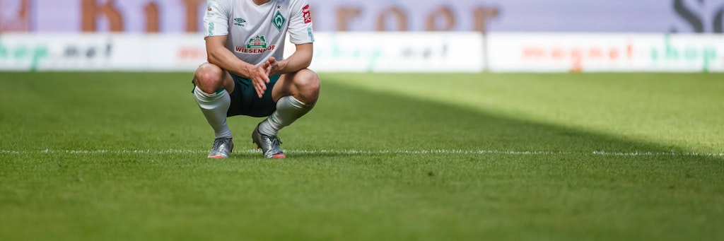 Bremens Fin Bartels hockt nach dem Abpfiff niedergeschlagen auf dem Rasen. Das 1:3 in Mainz ist fast schon die Entscheidung. Muss Werder nach 40 Jahren zurück in die Zweite Liga?