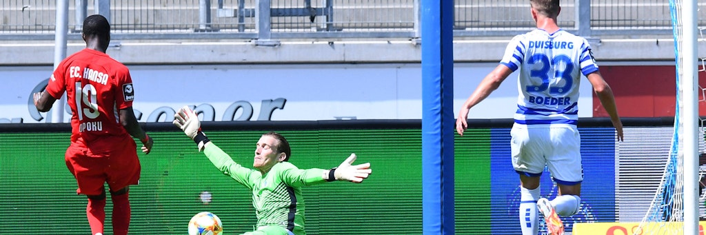 Rostocks Aaron Opoku schietert an Duisburgs Keeper Leo Weinkauf. Bei de Teams trennen sich 0:0. 