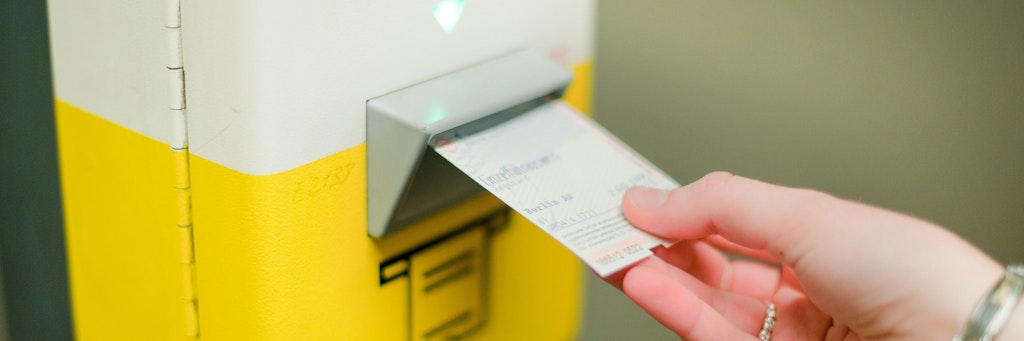 Eine Frau entwertet an einem Fahrkartenentwerter der Berliner Verkehrsbetriebe (BVG) in einem U-Bahnhof ihre Fahrkarte.
