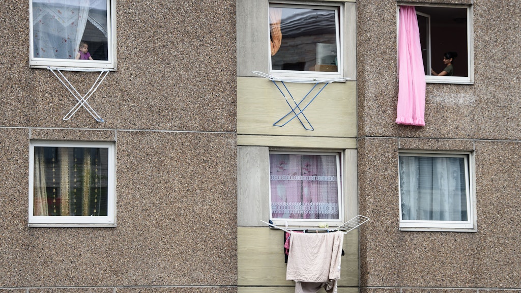 Bewohner eines unter Quarantäne gestellten Hauses in Göttingen hängen ihre Wäsche am Fenster auf.