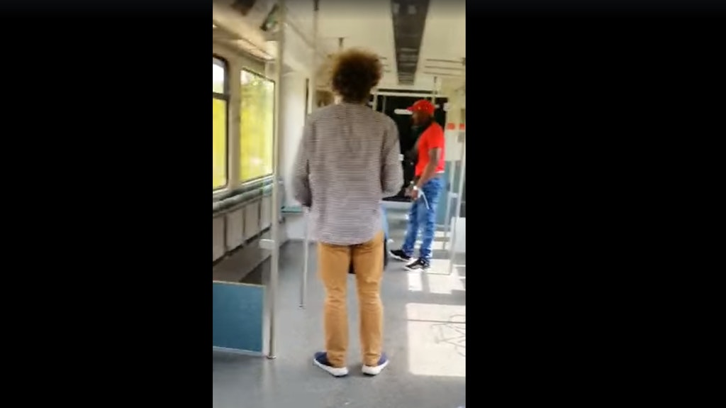 Der Mann im roten t-Shirt schreit auf die Frau (verdeckt) ein.