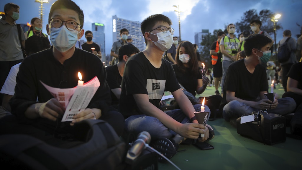Aktivist Joshua Wong (M.) hält eine Kerze bei einer Mahnwache zum Gedenken an die Opfer des 1989 auf dem Tiananmen-Platz verübten Massakers.
