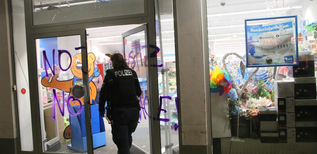Eine Beamtin betritt ein Geschäft, das bei der jüngsten Randale in Neukölln beschädigt wurde. 