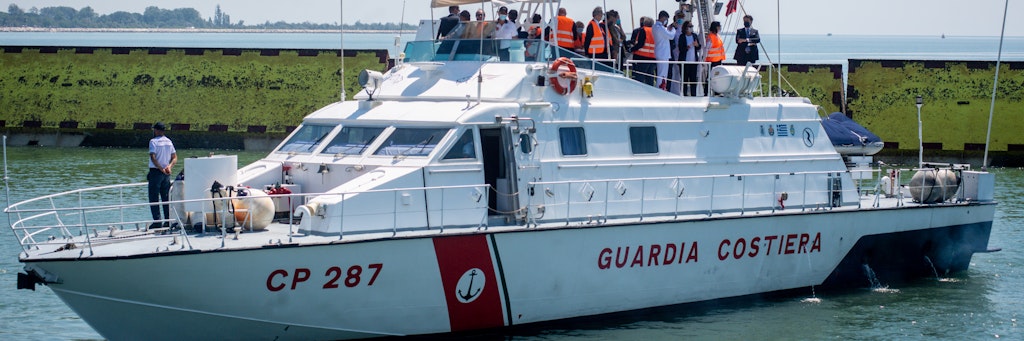 Von einem Boot aus beobachten Politiker und Wissenschaftler, wie das „Mose“-System hochfährt.