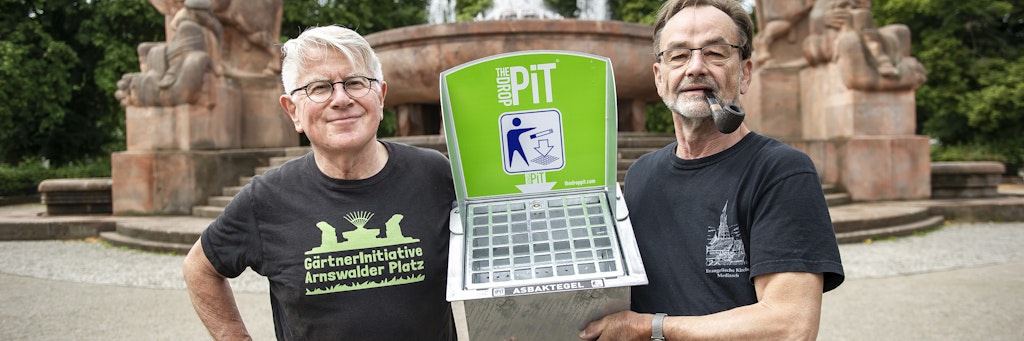 Carsten Meyer und Michael Pflug (rechts) von der „GärtnerInitiative Arnswalder Platz“ haben Aschenbecher für Kippen und Kronkorken unter den Parkbänken am Springbrunnen einbetoniert. Sie wünschen sich ein sauberes Bötzowviertel.