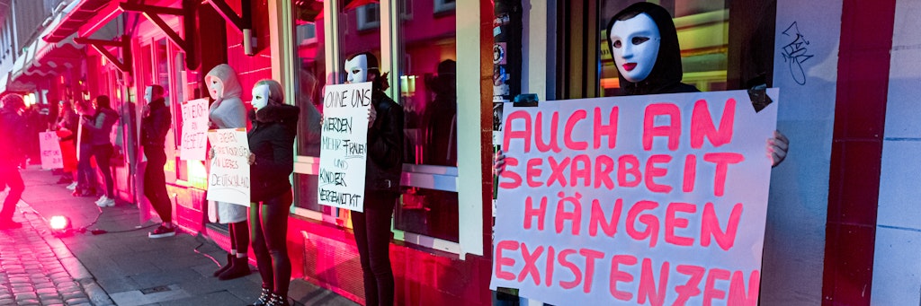Eine Prostituierte hält in der Herbertstraße ein Schild mit der Aufschrift «Auch an Sexarbeit hängen Existenzen». Sie demonstriert mit anderen Frauen für die Öffnung der coronabedingt geschlossenen Bordelle auf St. Pauli.