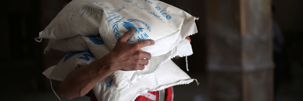 Ein Mann in Syrien trägt Hilfsgüter des World-Food-Programms der UN.