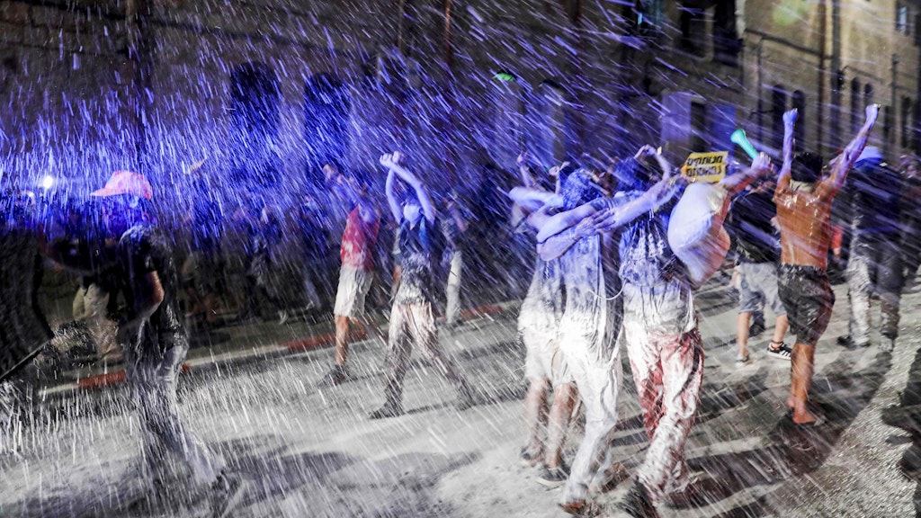 Mit Wasserwerfern drängen Polizei-Einheiten die Proteste gegen die Regierung zurück.