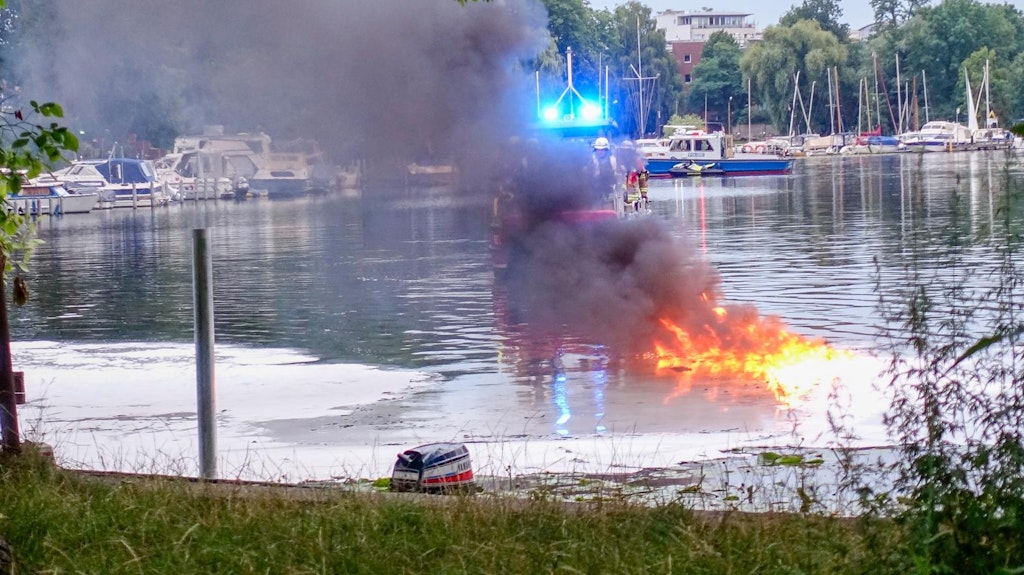 Von einem Löschboot aus kämpft die Feuerwehr gegen die Flammen auf dem brennenden Boot.
