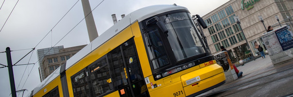 Eine Straßenbahn der Berliner Verkehrsbetriebe (BVG) fährt vor dem Fernsehturm über den Alexanderplatz.