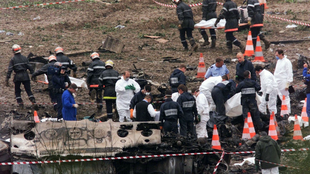 Feuerwehrleute tragen Leichen aus den Trümmern der Concorde.