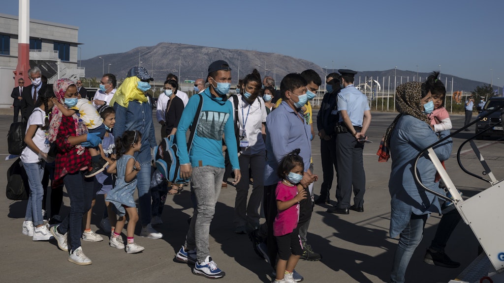 Migrantenkinder mit Gesundheitsproblemen und ihre Angehörigen steigen am Internationalen Flughafen in Athen in eine Maschine zu ihrem Flug nach Deutschland. Am Freitagabend kamen die Familien in Berlin an.