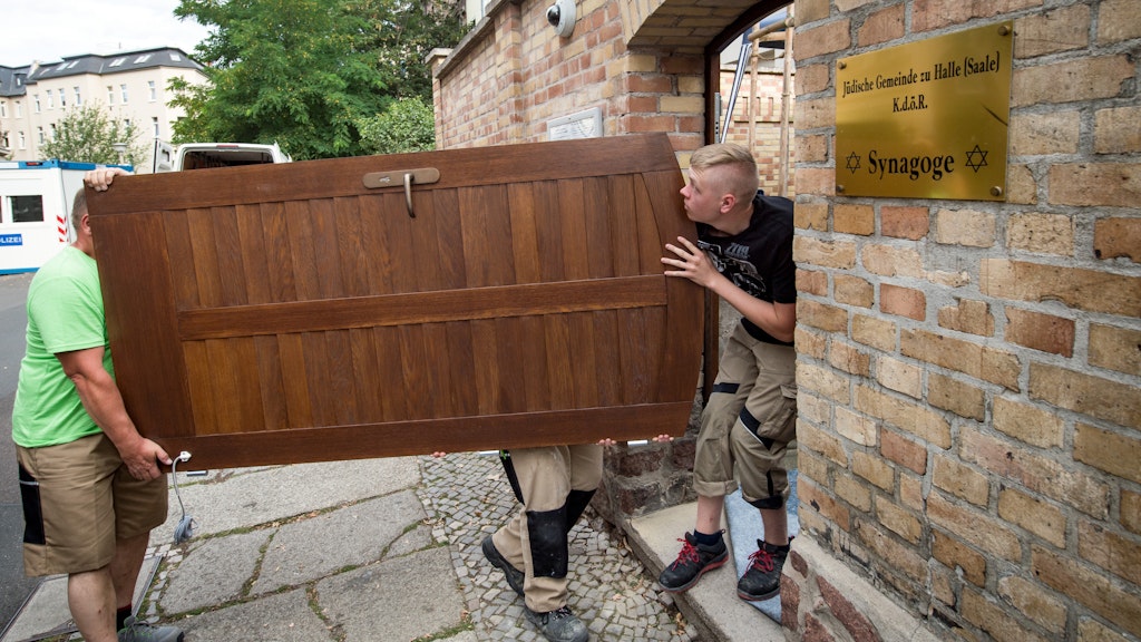  Thomas Thiele (l.) und seine Mitarbeiter wuchten die Tür zum Grundstück der Synagoge. 