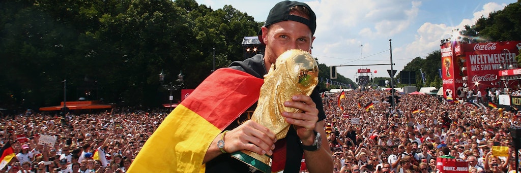 Benedikt Höwedes auf dem Höhepunkt seiner Karriere. Die WM-Trophäe in den Händen auf der Partymeile auf der Straße des 17.Juni.