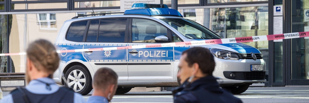 Polizisten stehen nach einer Bombendrohung vor dem Justizzentrum Erfurt.