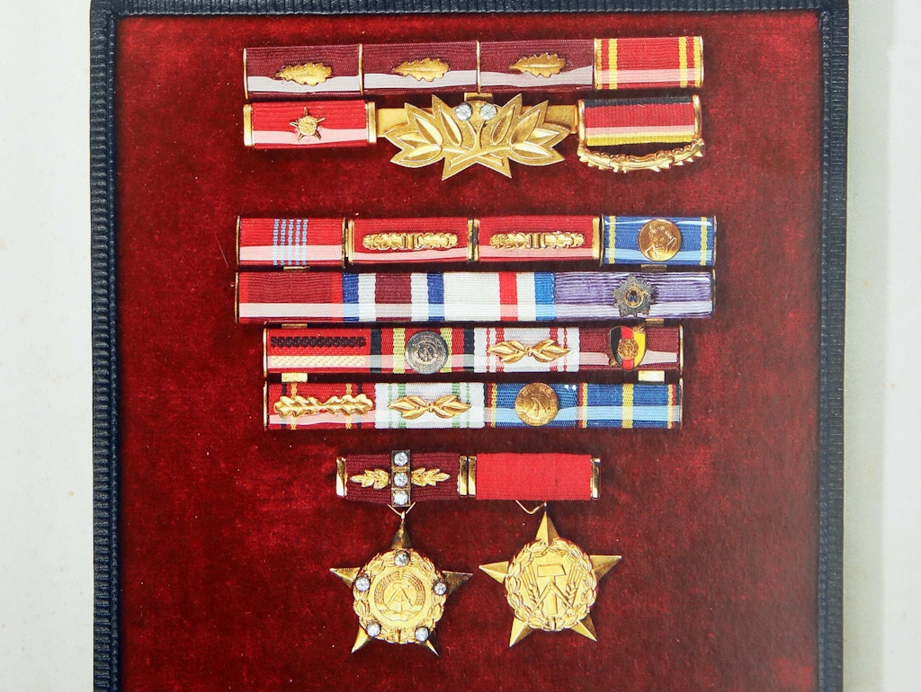 Ordensspangen Erich Honeckers. Das Bändchen mit dem schwarz-rot-goldenen Schild wies ihn als „Verdienten Mitarbeiter der Staatssicherheit“ aus. 