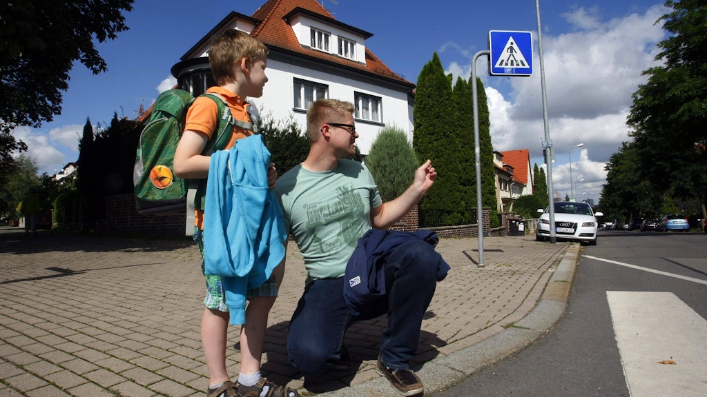Sich beim Üben des Schulweges auf Augenhöhe des Kindes zu begeben, hilft Eltern dabei, potenzielle Gefahren besser einzuschätzen.