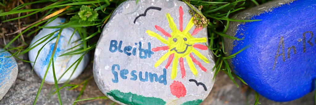 Bemalte Steine liegen an einem Wegesrand. Sie zeigen die Verbundenheit und den Zusammenhalt der Bürger in Zeiten der Corona-Pandemie. 