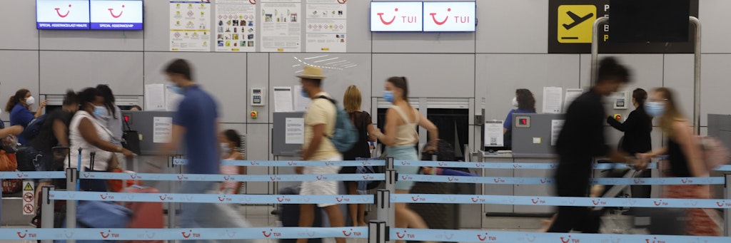 Am Flughafen von Palma auf Mallorca wollen Passagiere an einem Tui-Schalter einchecken.