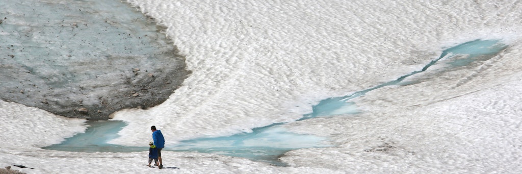 Zwei Wanderer gehen über den Schneeferner-Gletscher auf der Zugspitze.
