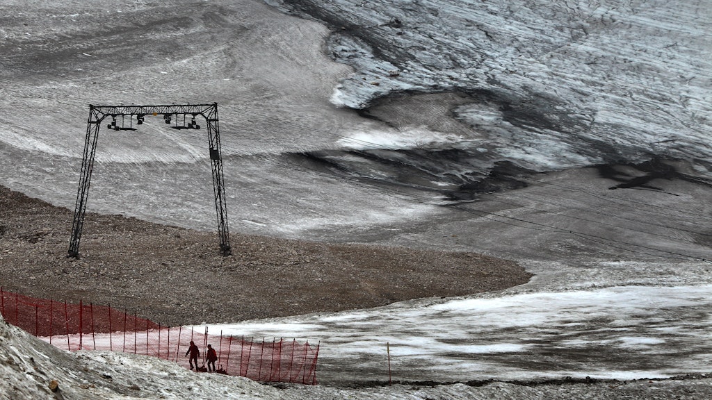 Ausflügler gehen auf Schneeresten des Schneeferner-Gletscher auf dem Zugspitzblatt einen Hang hinauf..