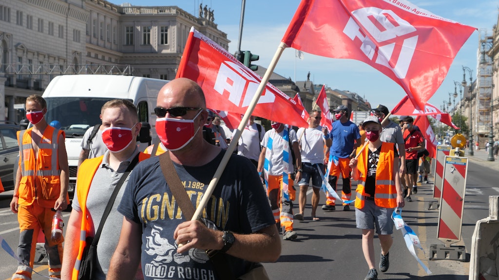 Bauarbeiter-Demo mit Mundschutz und Bändern als Abstandhaltern.