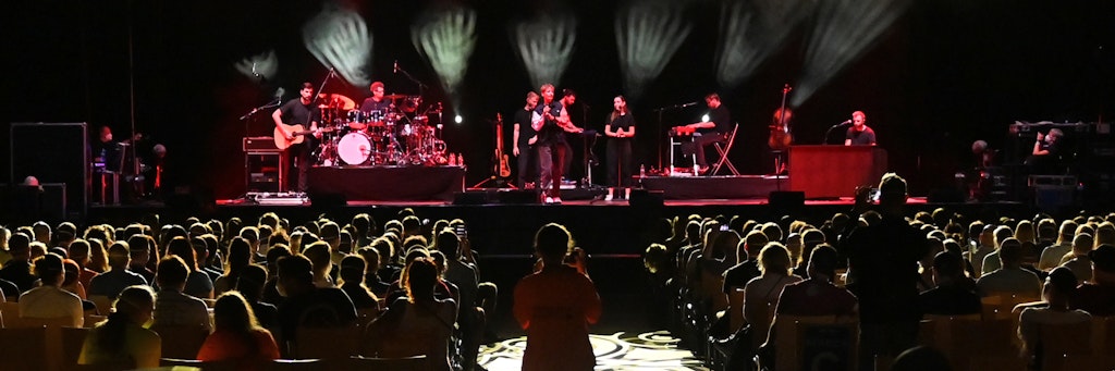Der deutsche Popsänger Tim Bendzko (M., hinten) tritt während eines Großversuchs der Universitätsmedizin Halle (Saale) in der Arena Leipzig mit einer Band auf der Bühne auf. 