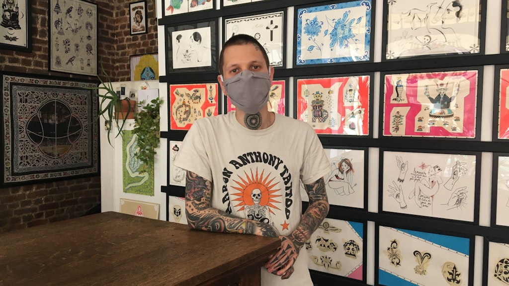 Tätowierer Indy Voet vor Bildern seiner Tattoo-Kreationen. Monia Mersni/dpa