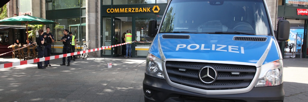 Die Polizei steht vor der Commerzbank-Filiale am Kudamm, sichert Spuren des Überfalls.