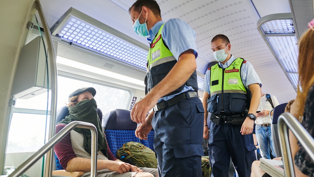 Bahn-Mitarbeiter und Beamte der Bundespolizei kontrollieren die Einhaltung der Maskenpflicht in einer Bahn in Berlin.