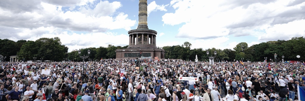 Teilnehmer einer Demonstration gegen die Corona-Maßnahmen stehen auf der Straße des 17. Juni und um die Siegessäule.